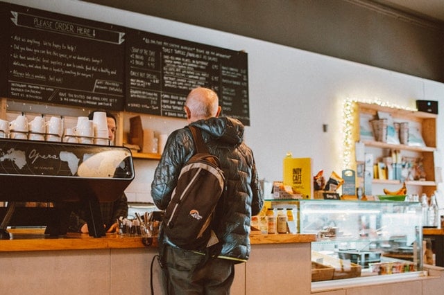 Man standing at a coffee counter 