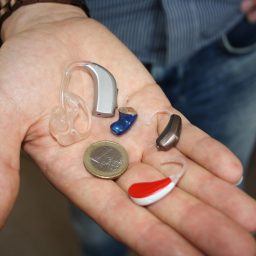 hand with various hearing aids