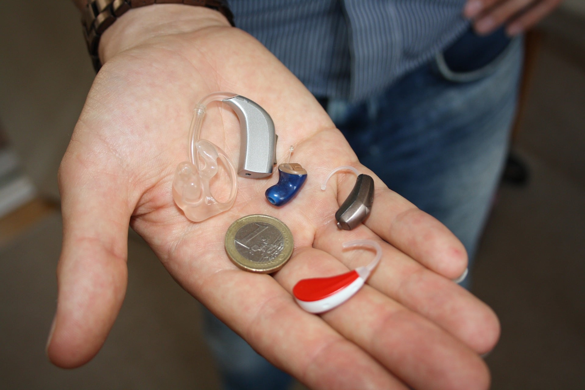 hand with various hearing aids