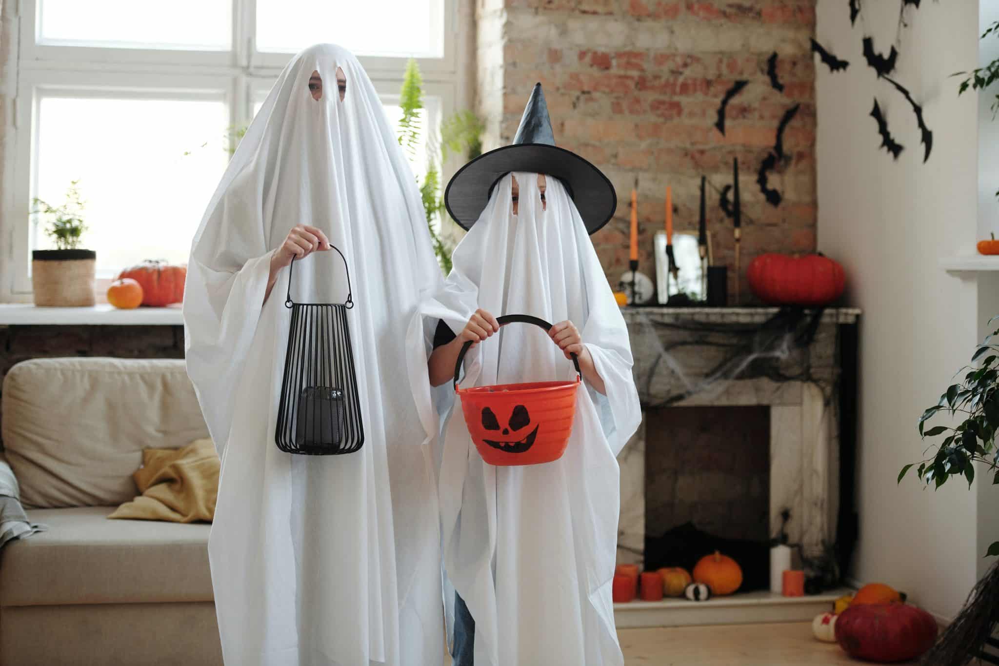 A parent and child dressed up as ghosts for Halloween.