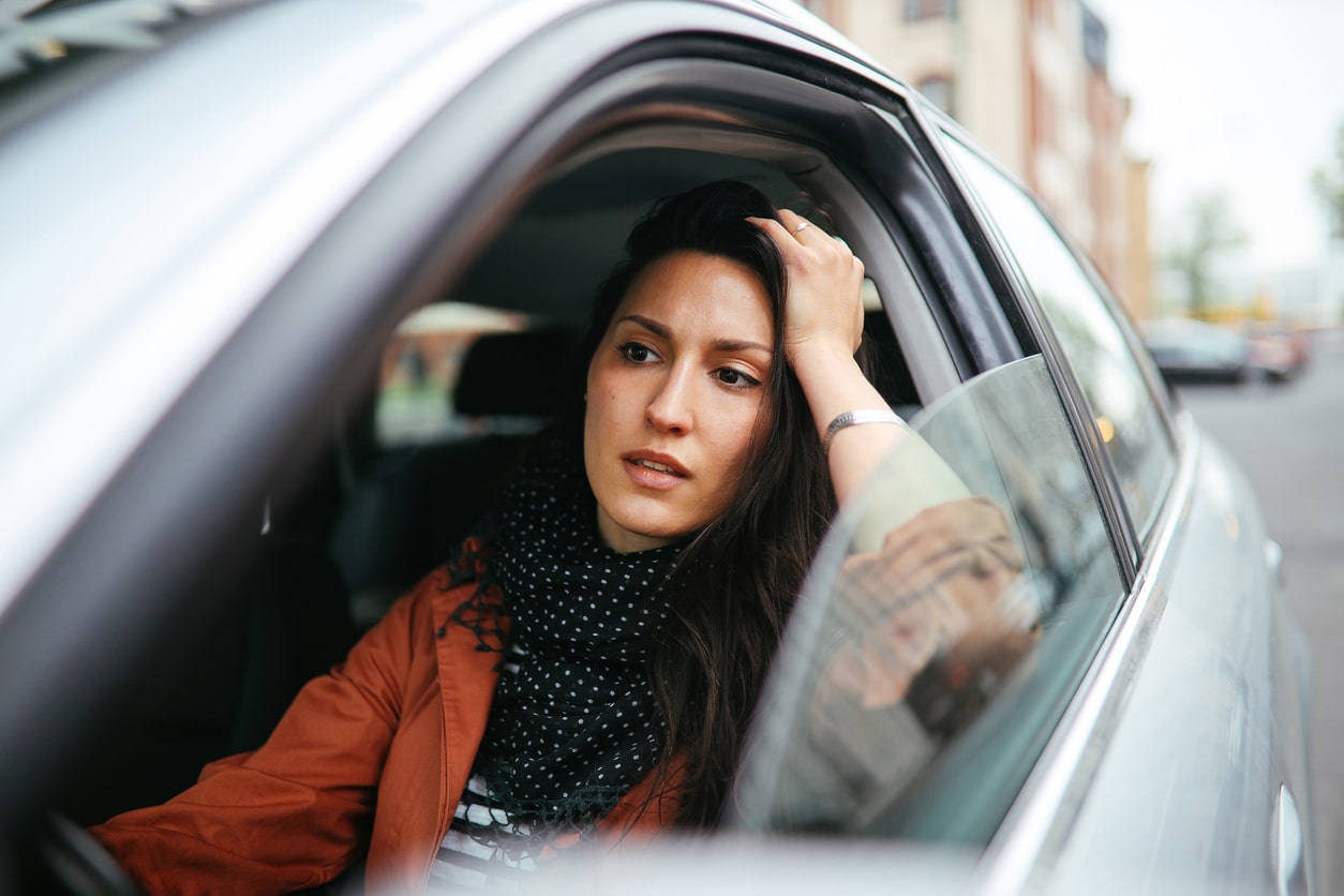 Woman sitting in traffic looking frustrated.