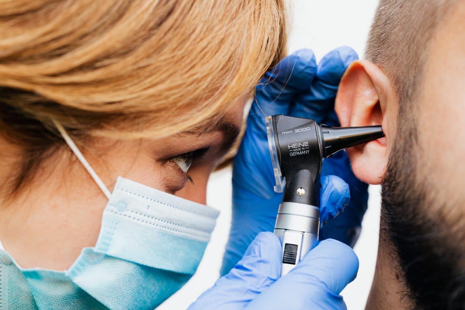 Doctor examining a man's ear.