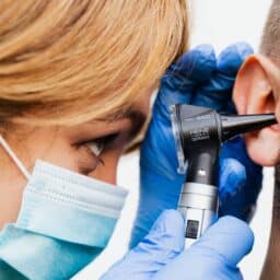 Doctor examining a man's ear.