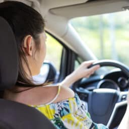 Young woman driving with a hearing aid