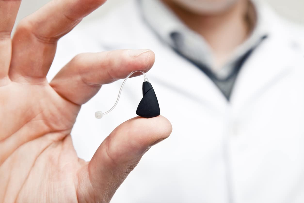Doctor holds hearing aid