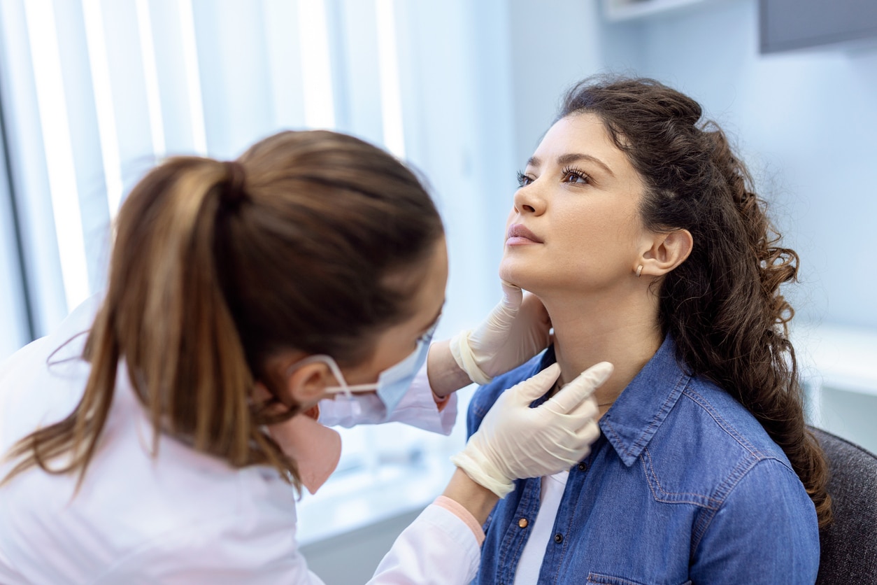 A woman gets her thyroid checked by an ENT doctor.