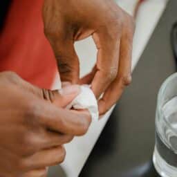 Hands cleaning a hearing aid